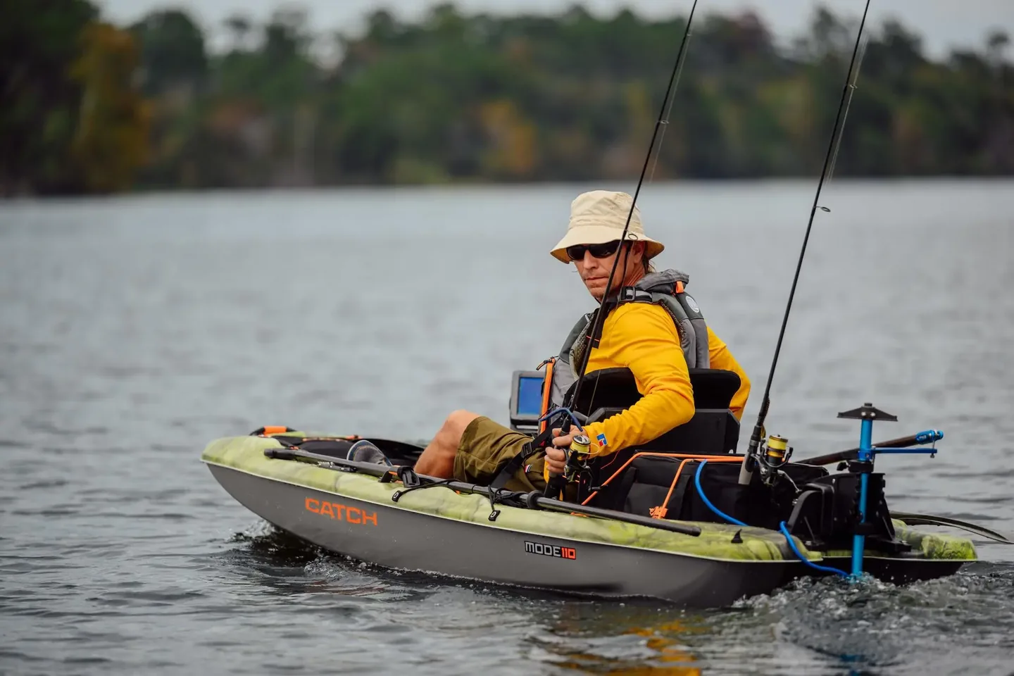 An angler fishing from a kayak on a quiet stretch of water